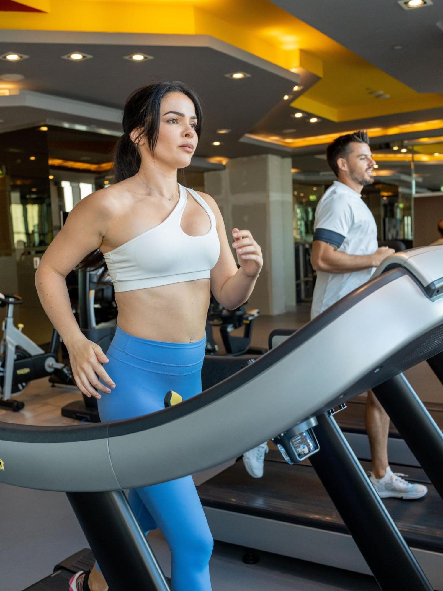 V Hotel Dubai, Curio Collection By Hilton Eksteriør bilde A woman and a man on a treadmill
